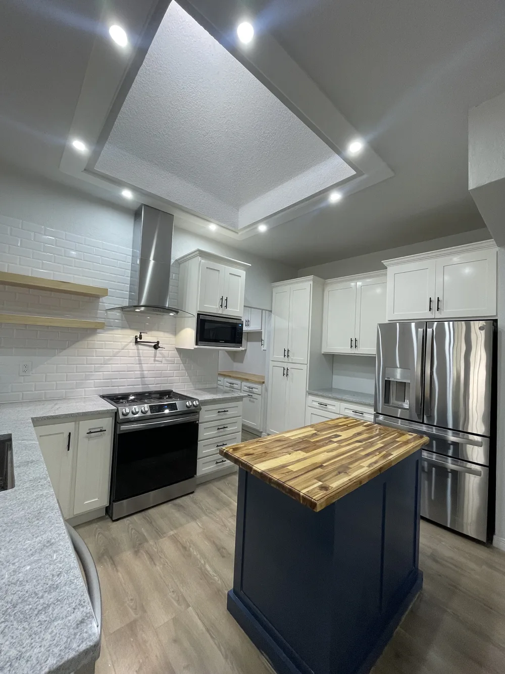 Modern white kitchen remodel with butcher-block island, Rose Gold Group El Paso